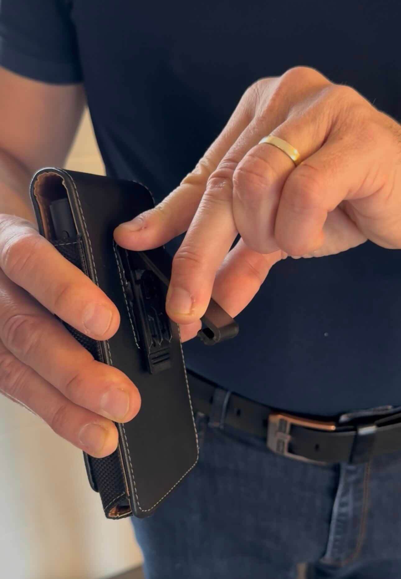 Person utilisant un etui de telephone ou de traducteur premium en cuir avec clip de ceinture.